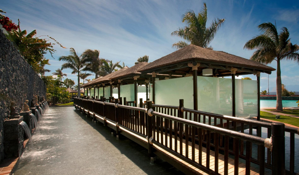 Vialetto in legno con palme e mura all'Hotel Villa Cortés Tenerife.