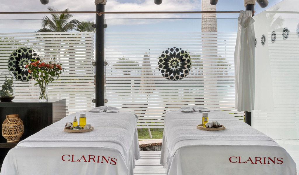 Lettino da massaggio con oli nella Clarins spa, Tenerife, accanto a una finestra decorata.