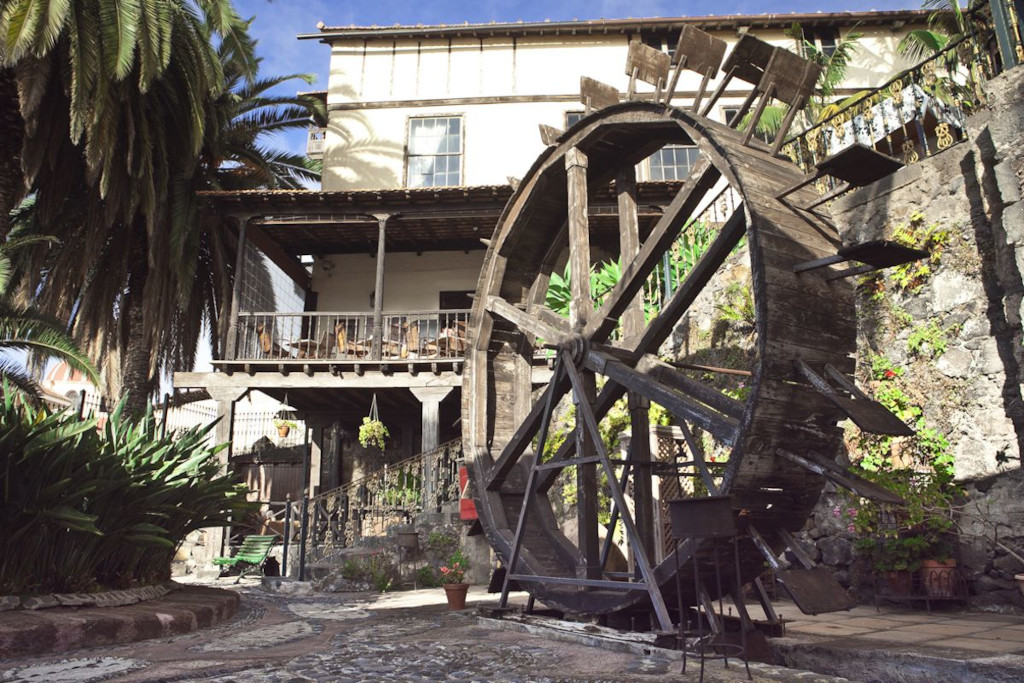 Vecchio mulino ad acqua a La Orotava, circondato da vegetazione e architettura classica.