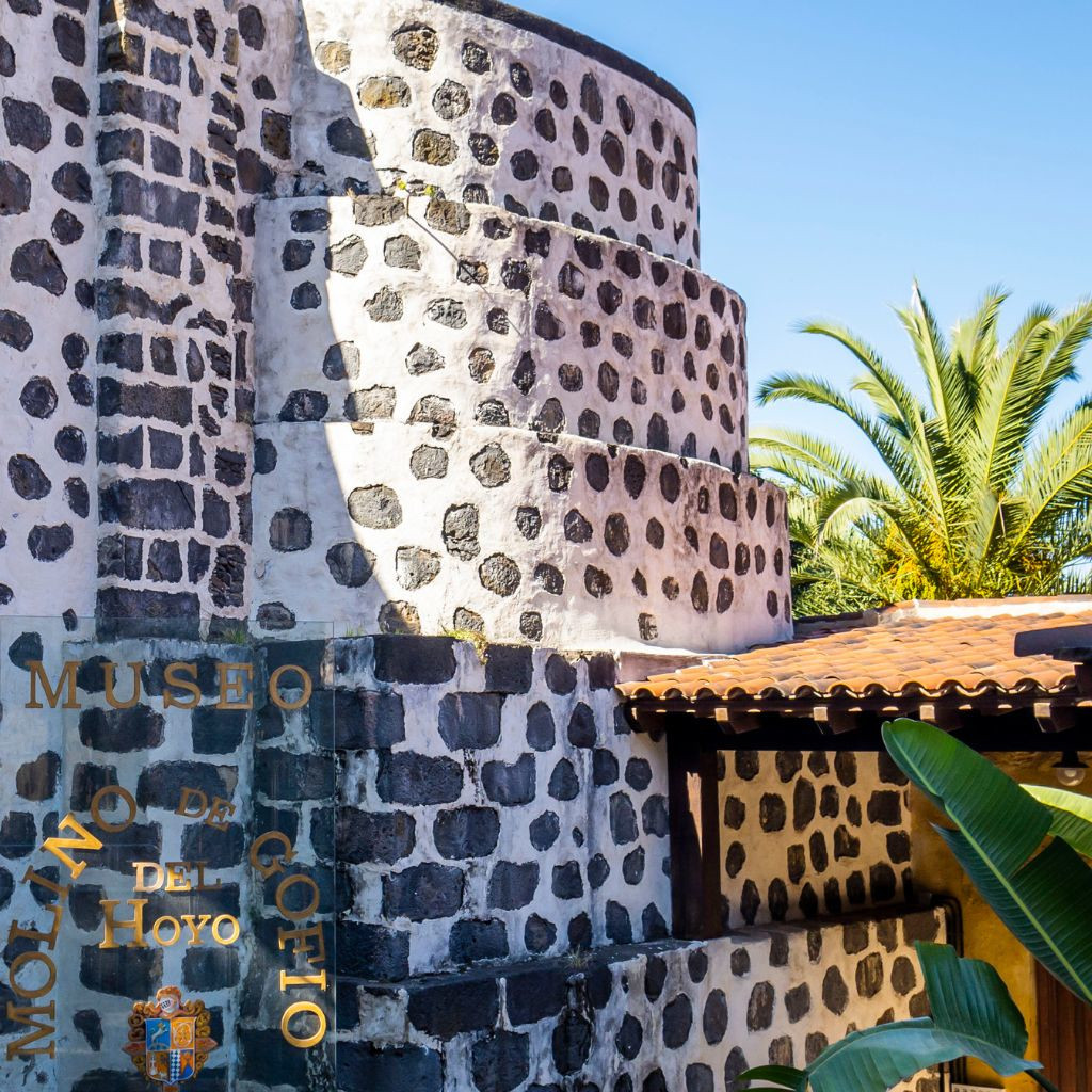 Mulino Gofio del Hoyo a Tenerife con palme sullo sfondo.