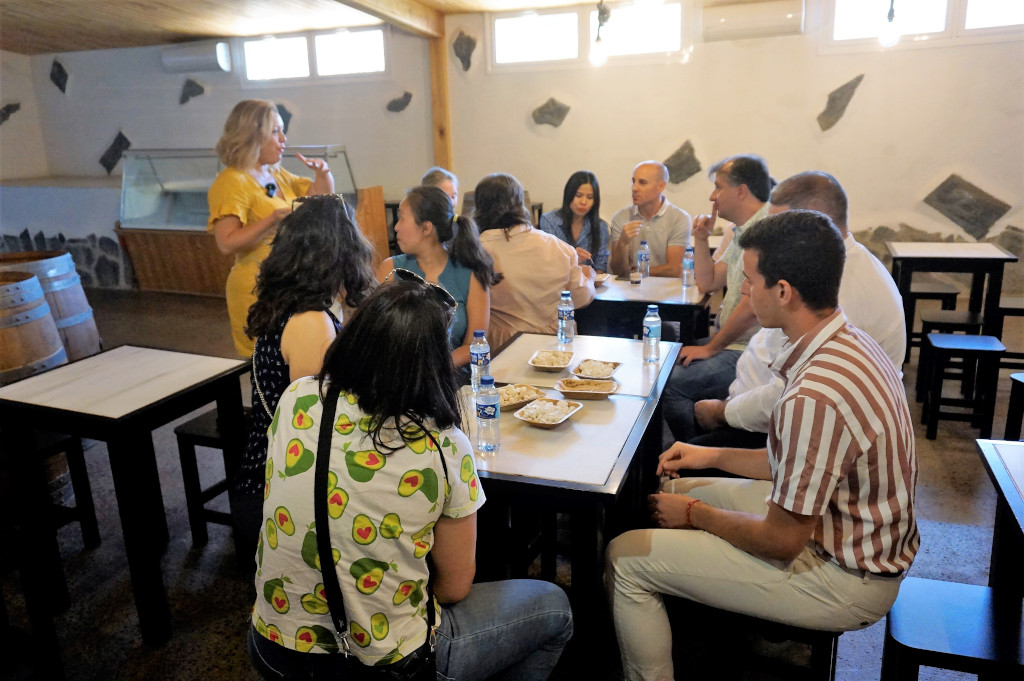 Un gruppo di persone si è riunito in una cantina a Tenerife, condividendo il cibo intorno ai tavoli.