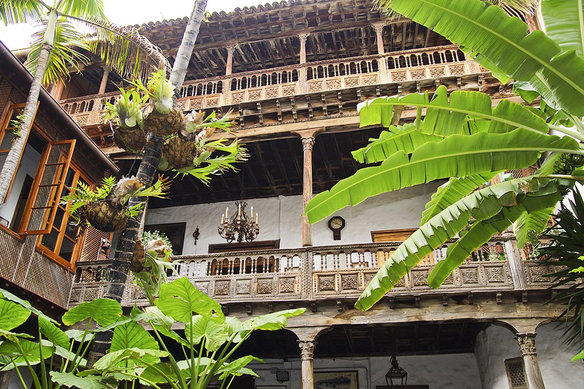 Balcone in legno circondato da piante in un edificio tradizionale a Tenerife.