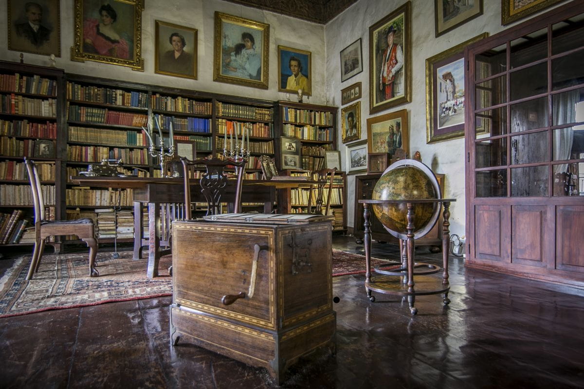 Vecchia biblioteca con scaffali pieni di libri e un globo, a Tenerife.