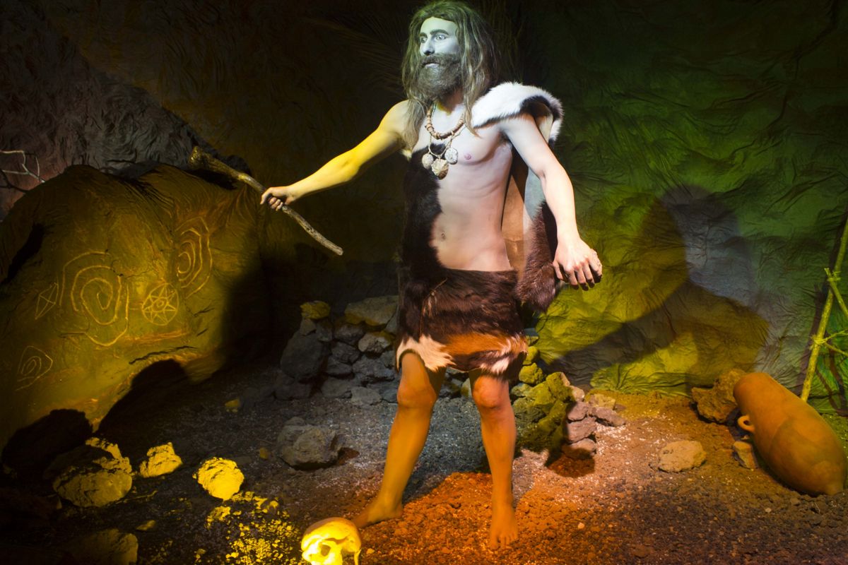 Uomo preistorico con abiti di pelliccia in una grotta, Tenerife.