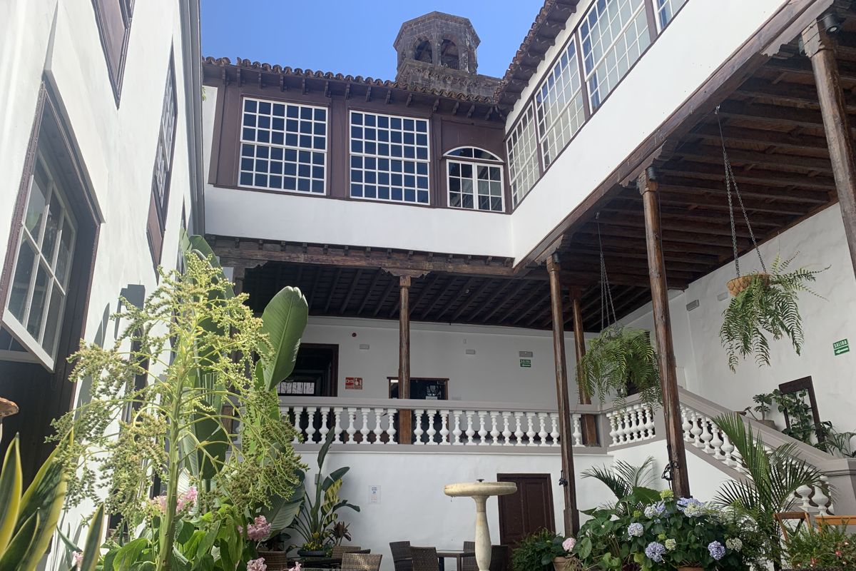 Cortile interno con piante e scale nell'edificio storico di Tenerife.