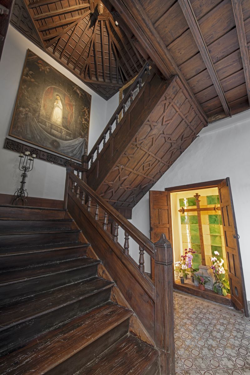 Scala di legno con dipinto religioso e vetrate colorate in una casa a Tenerife.