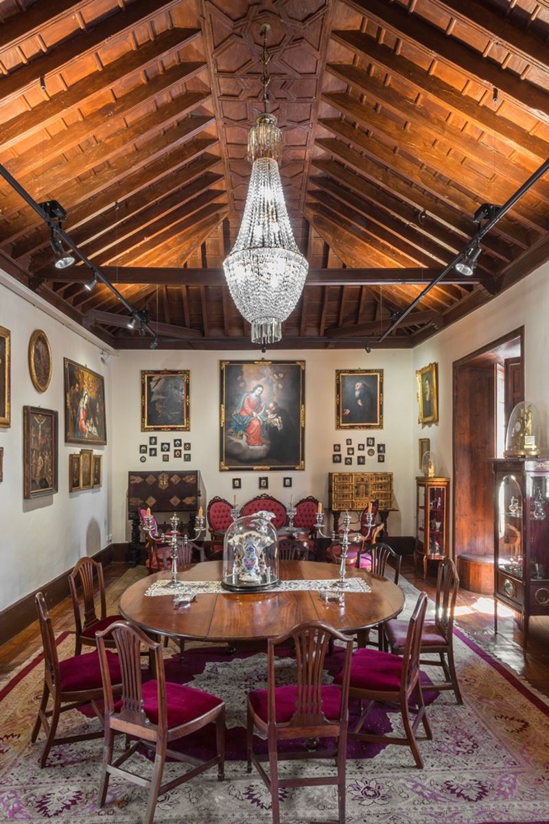 Sala da pranzo con lampadari, tavolo rotondo e soffitto in legno, a Tenerife.