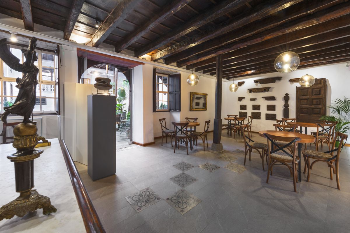 Interno di un caffè storico a Tenerife con tavoli in legno e arredamento classico.