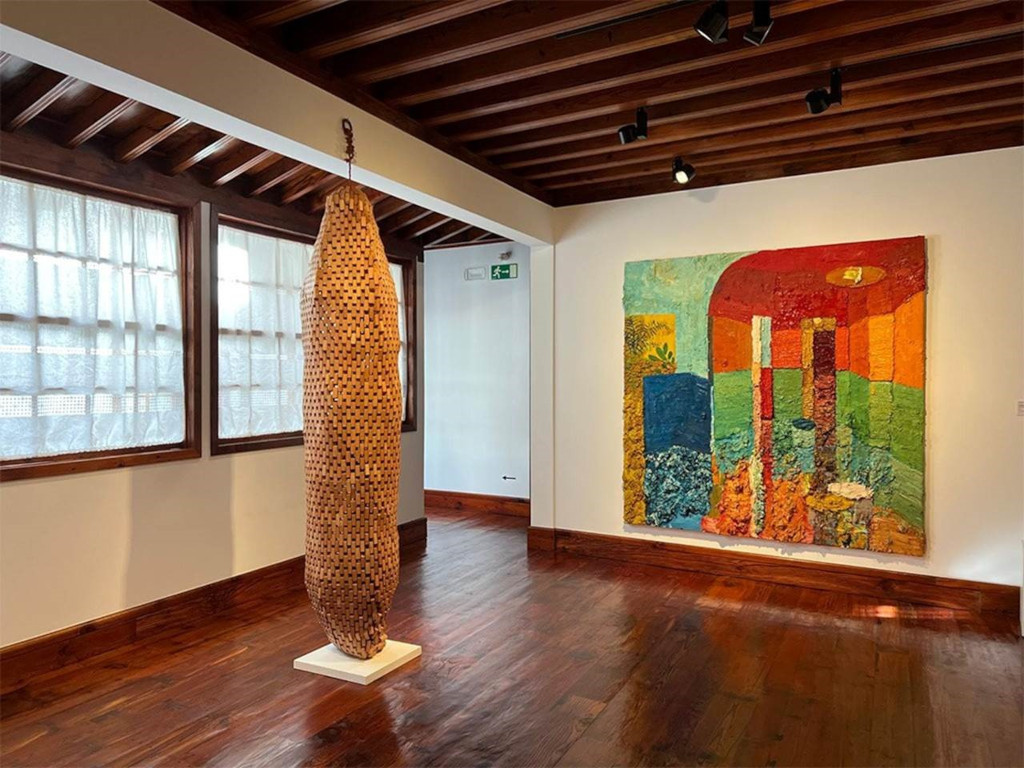 Scultura in legno e pittura astratta in una sala d'arte a Tenerife.