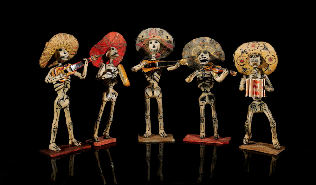 Mariachi di scheletri con strumenti e cappelli.