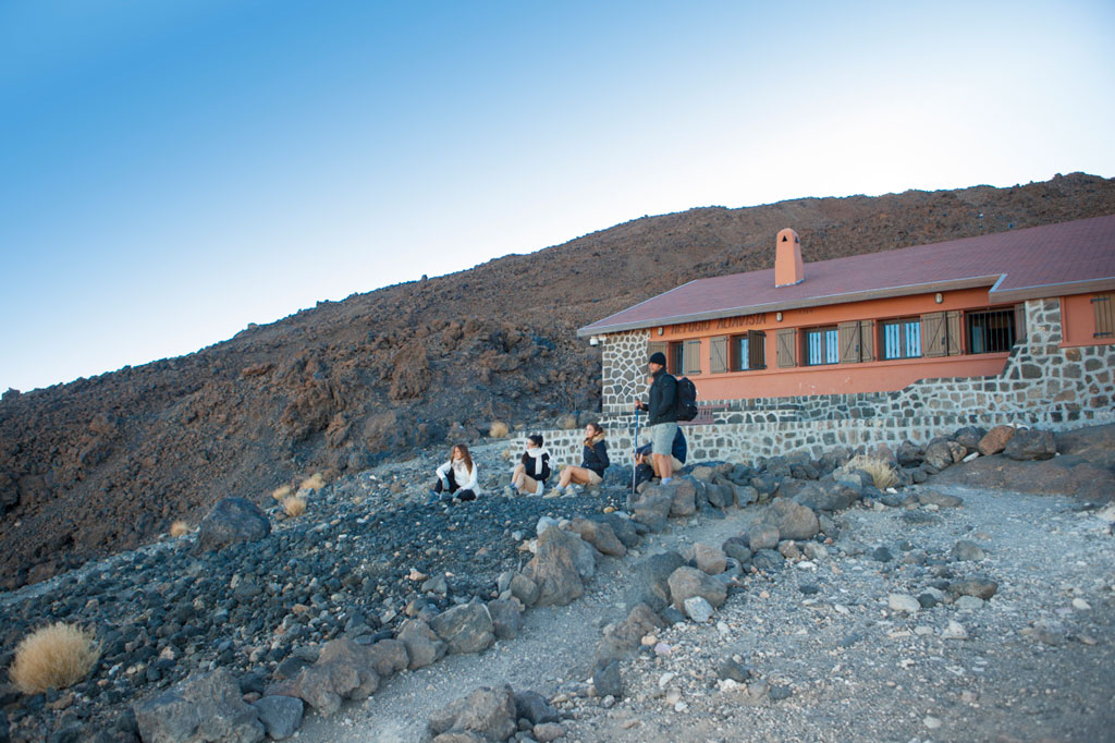 Persone che riposano davanti al Rifugio di Altavista nel Parco Nazionale del Teide, Tenerife.