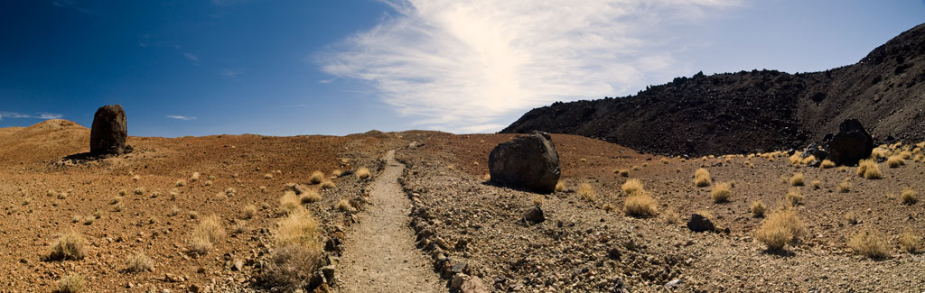 Sentiero in un paesaggio vulcanico arido con grandi rocce nel Parco Nazionale del Teide, Tenerife.