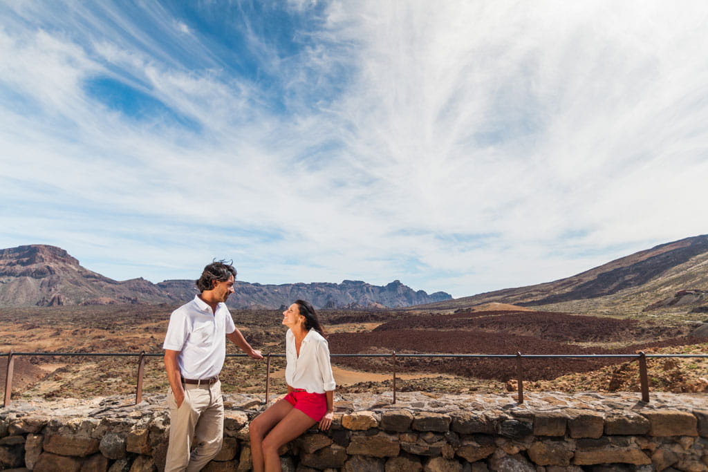 Una coppia che conversa con il paesaggio del Monte Teide sullo sfondo.