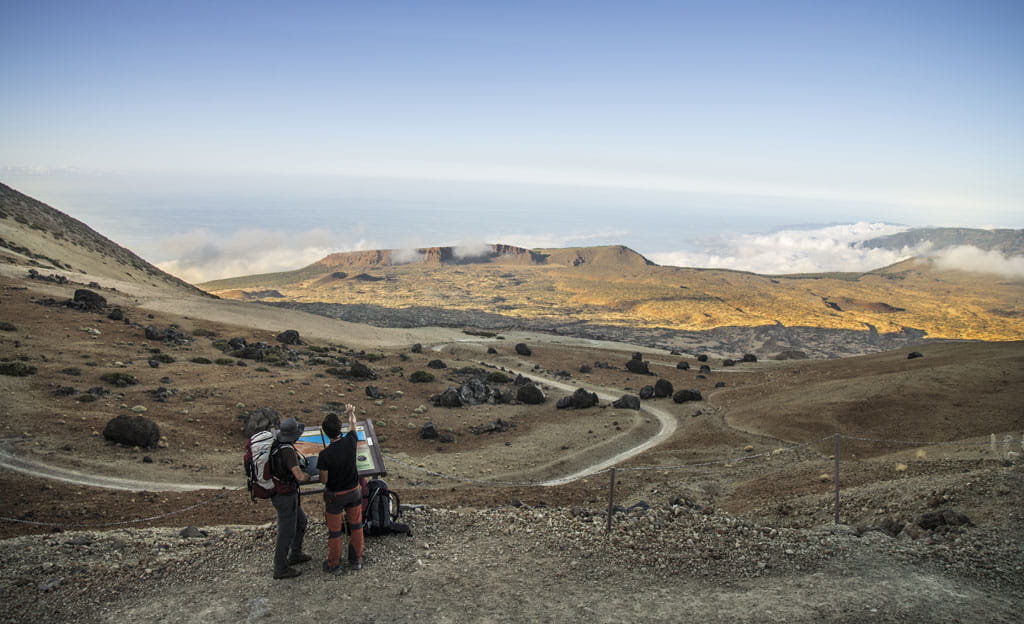 Sentiero nel Parco Nazionale del Teide, Tenerife, con due persone che osservano il paesaggio.