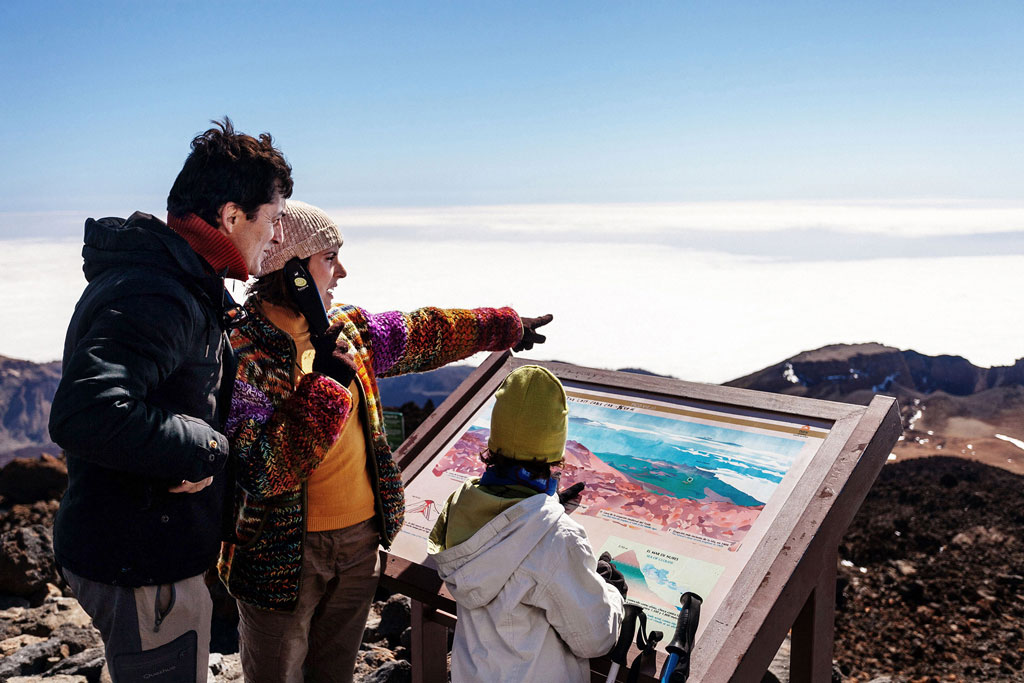 La famiglia guarda una mappa nel Parco Nazionale del Teide, Tenerife.