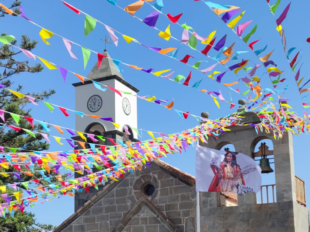 Torre della chiesa a Tenerife con coloriti pennoni e bandiera di Santa Úrsula.