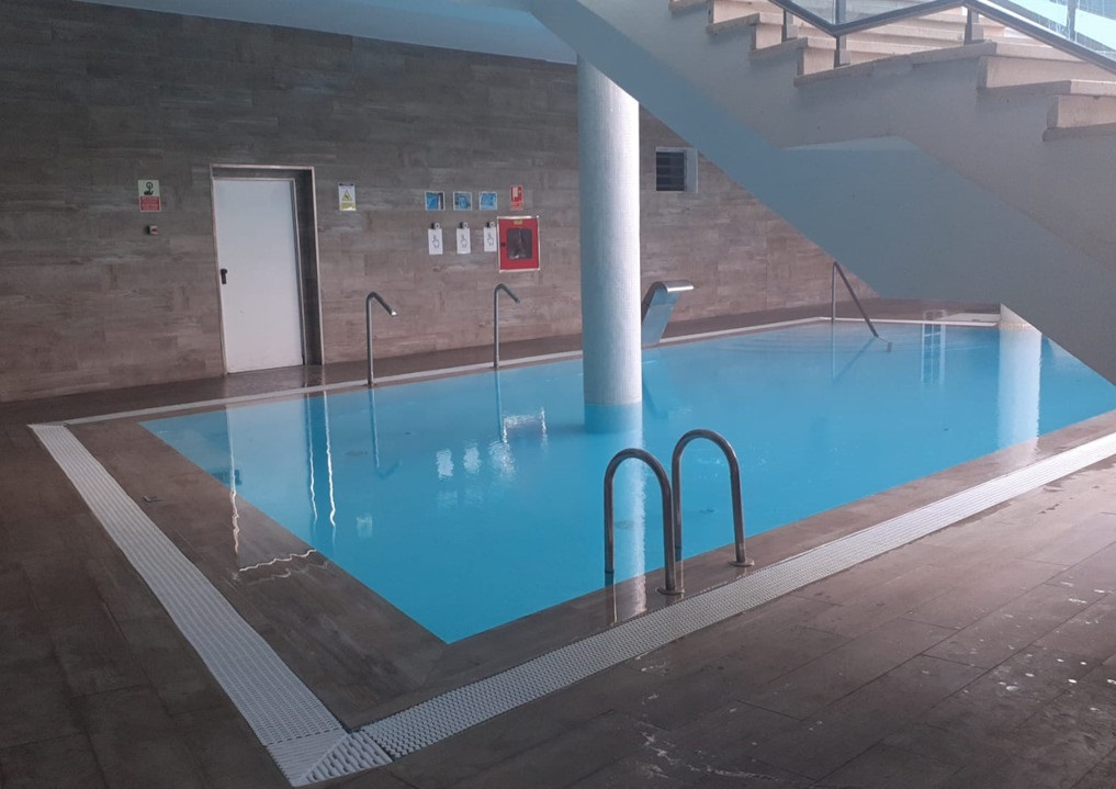 Piscina coperta con scale e cartelli apposti alle pareti a Tenerife.