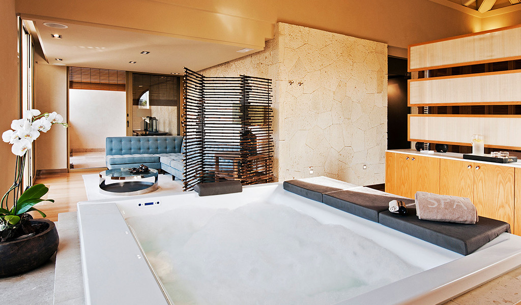 Jacuzzi in spa con divano blu e orchidea bianca a Tenerife.