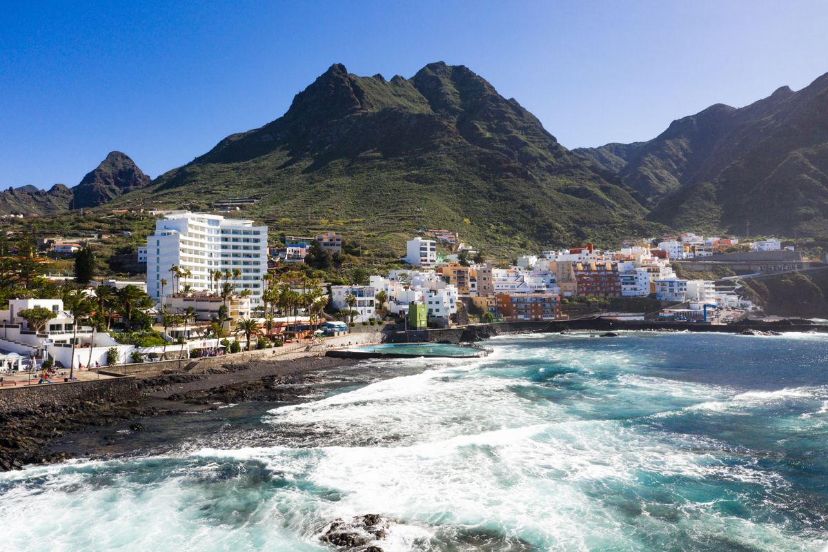 Costa e montagne a La Laguna, Tenerife, con edifici e costa rocciosa.