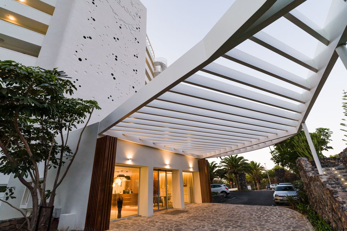 Ingresso moderno di un hotel a Tenerife con struttura a tetto bianco.