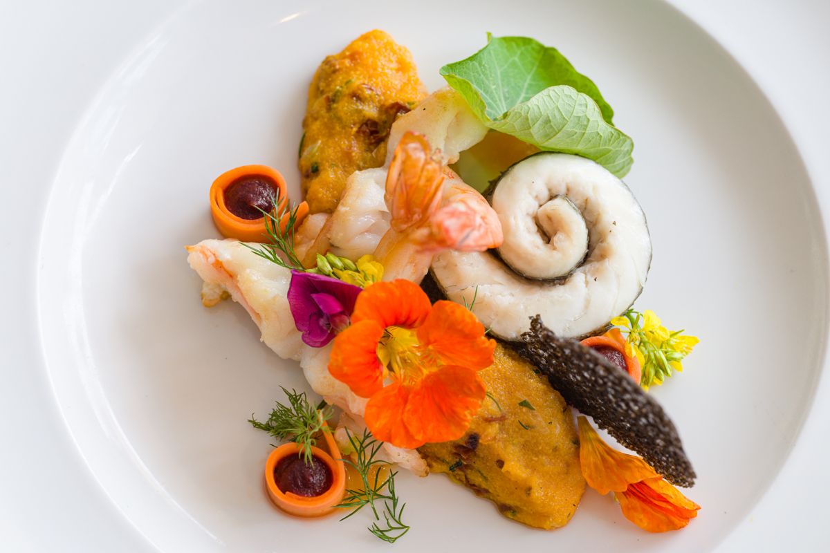 Piatto gourmet con frutti di mare, fiori commestibili e purea a Tenerife.