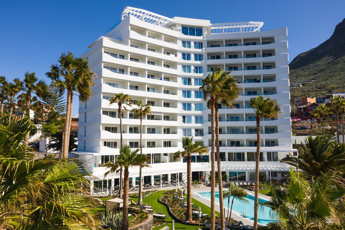 Hotel multipiano con palme e piscina a Tenerife.